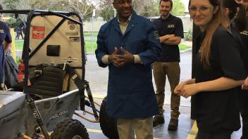 Chancellor May visits the College of Engineering Aggie Baja lab and prepares to take the student designed racecar for a ride. 