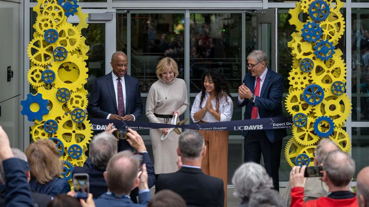 Diane Bryant cuts the ribbon to open the Engineering Student Design Center that bears her name as Chancellor Gary S. May, mechanical engineering major Tichada Tantasirikorn and Dean Richard Corsi look on. 