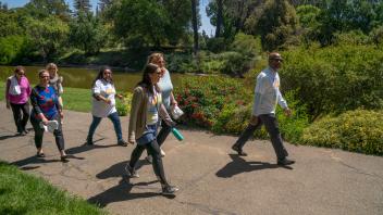 The Chancellor leads a walk through a grassy path at UC Davis.  