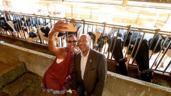 Chancellor Gary May and LeShelle May pose for a selfie with cows. 