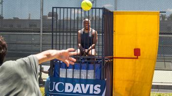 Photo of Chancellor Gary May sitting in a dunk tank while someone out of frame throws a ball toward the target