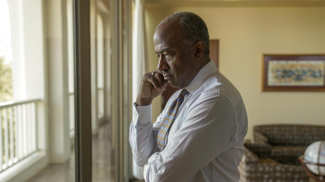 Chancellor Gary May seriously and thoughtfully looking out a window