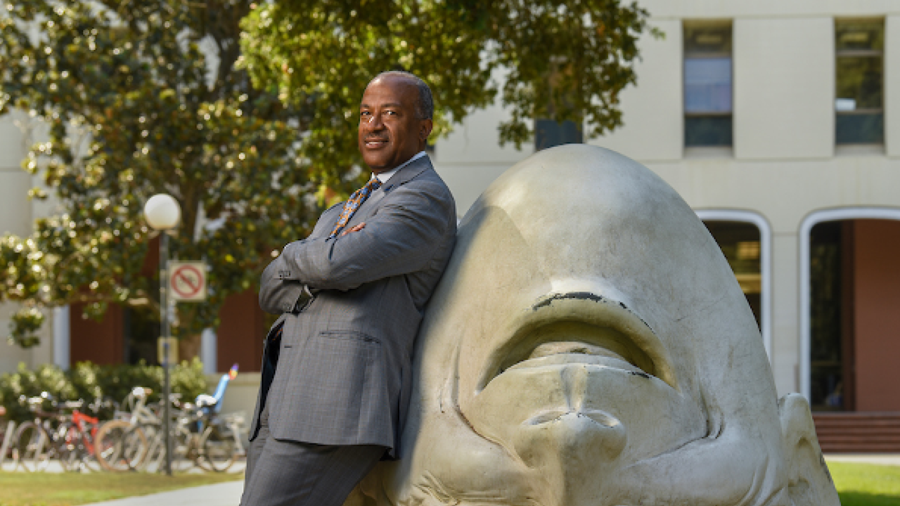 Chancellor May leaning on an Egghead in front of Mrak Hall.