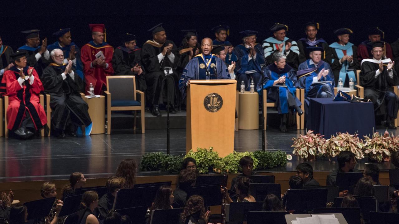 UC Davis Chancellor Gary May speaks behind a podium at his Investiture