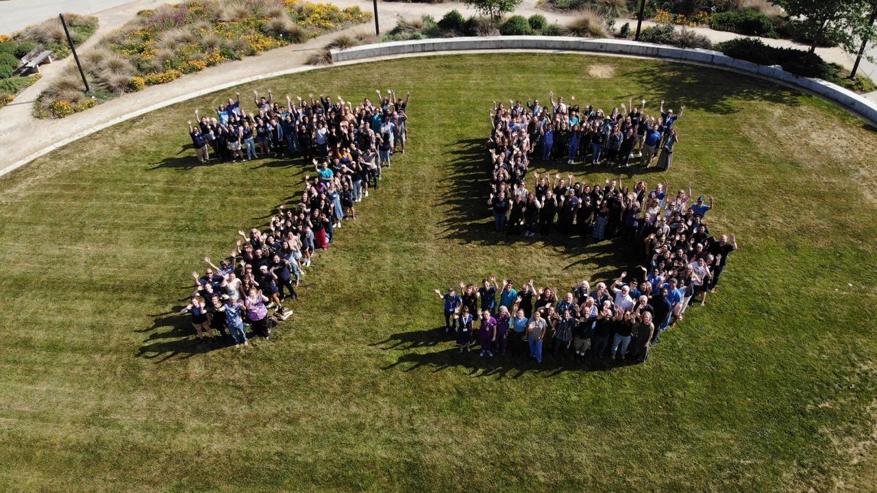Number 75 on a field formed by people.