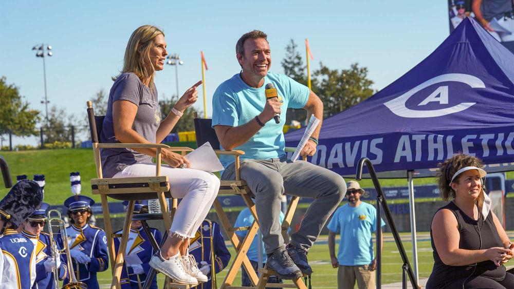 Two hosts sitting on stage at The College Tour watch party.