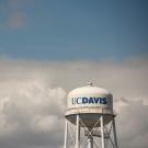UC Davis water tower against a backdrop of fluffy clouds.