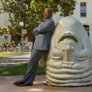 Chancellor May leaning on an Egghead in front of Mrak Hall. 