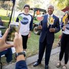 UC Davis Chancellor Gary May poses for pictures with students outside during a visit to the UC Davis Farmers Market.